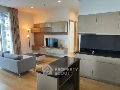 Modern open-layout living room and kitchen with sleek cabinetry and stylish decor.
