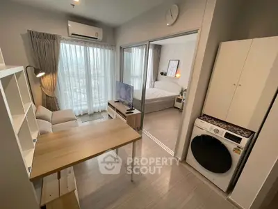 Modern apartment interior with open living room and bedroom, featuring a washing machine and stylish decor.