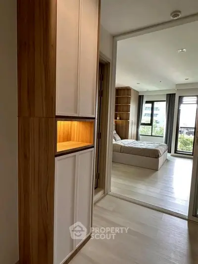 Modern bedroom with large windows and wooden accents, offering a bright and airy atmosphere.