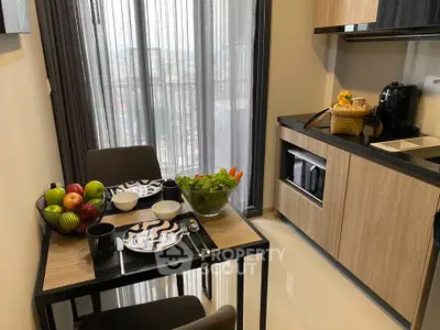 Modern kitchen with dining table, sleek cabinets, and large window view.