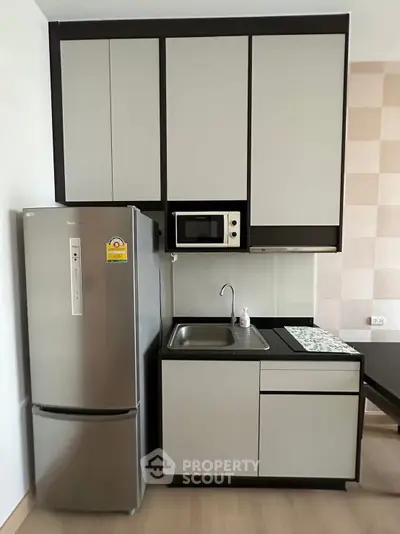 Modern compact kitchen with sleek cabinets and stainless steel appliances.