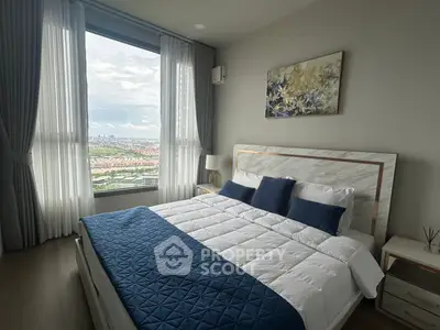 Modern bedroom with large window offering stunning city view, featuring elegant decor and cozy bedding.