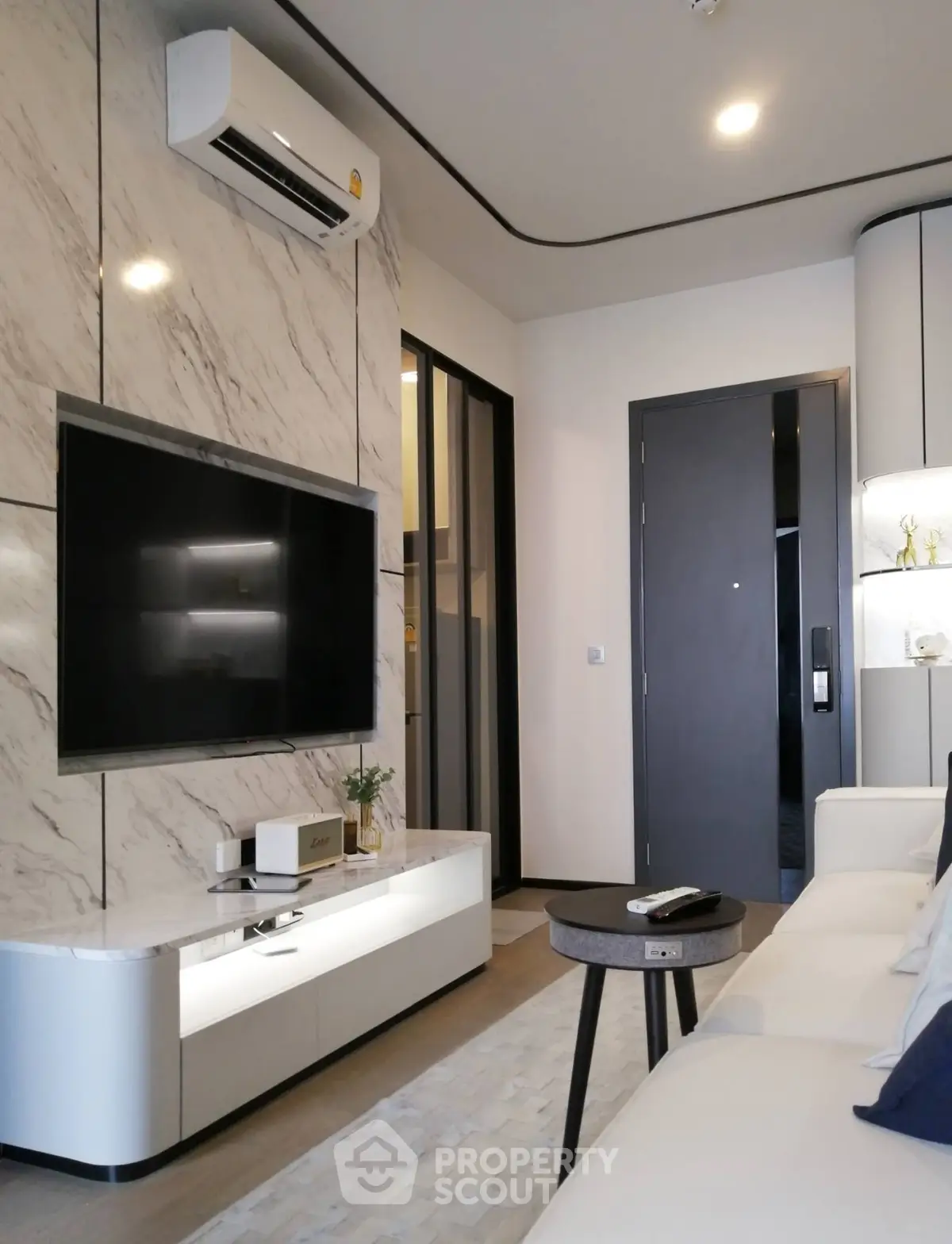 Modern living room with marble wall, sleek TV setup, and stylish furniture