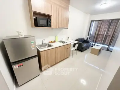 Modern open-layout kitchen and living room with sleek appliances and stylish decor.