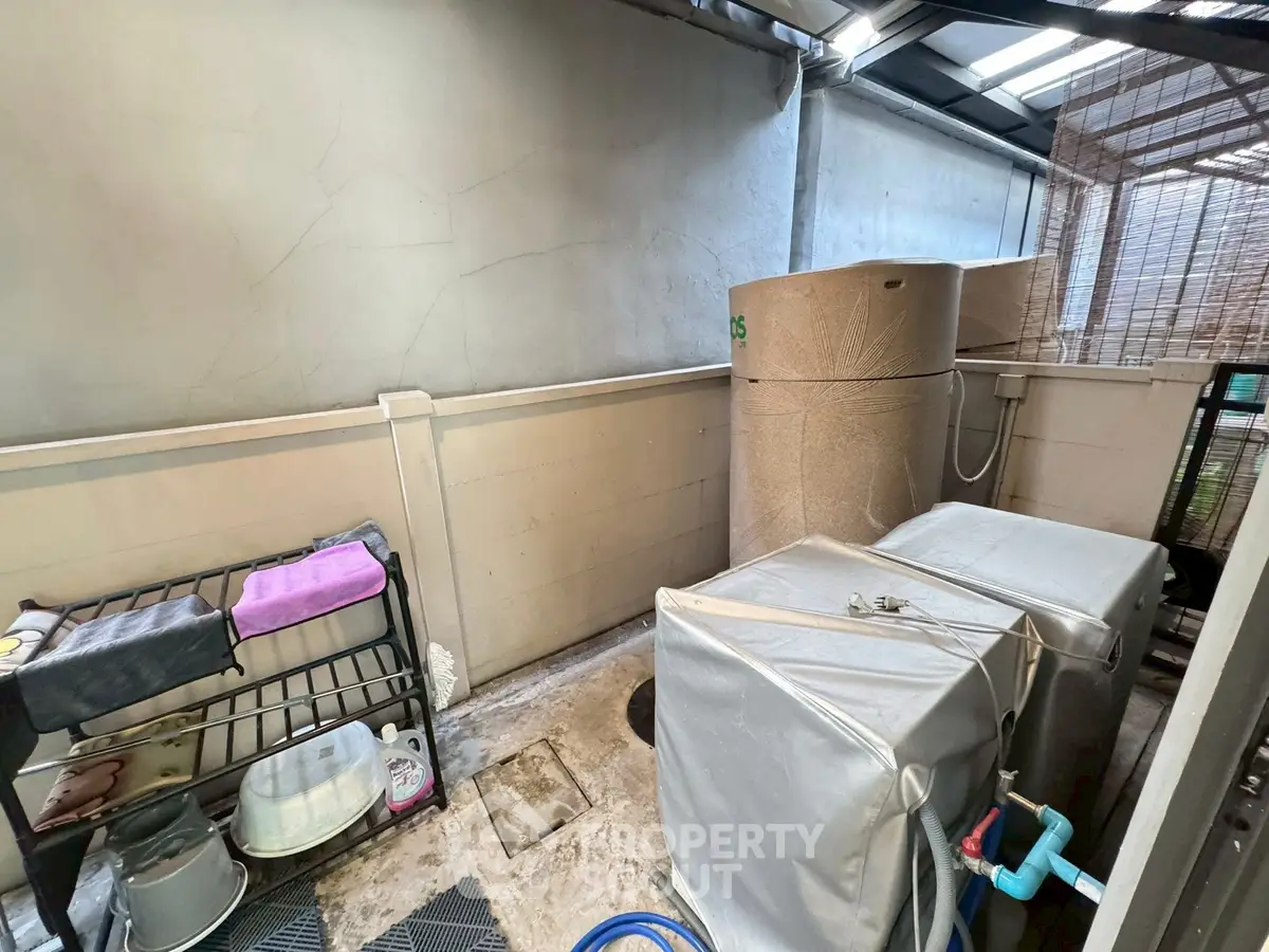 Outdoor utility area with storage tanks and shelving in a residential property