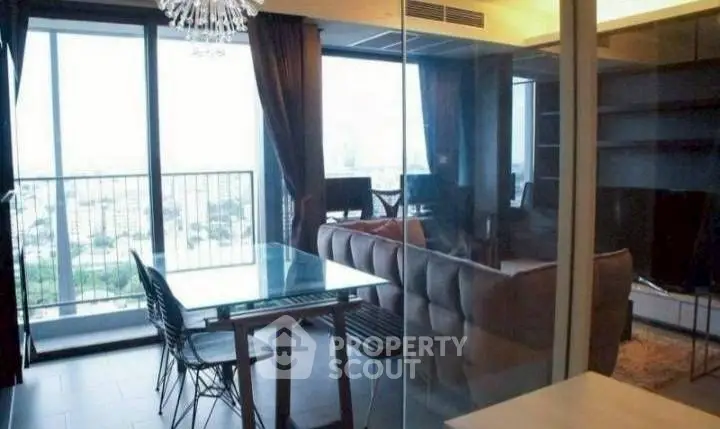 Modern living room with large windows and city view, featuring stylish furniture and elegant lighting.