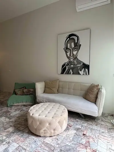 Stylish living room with modern art, plush sofa, and unique marble flooring.