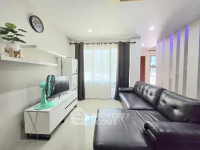 Modern living room with sleek black leather sofa and stylish decor