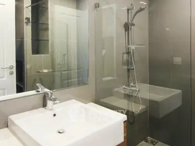 Modern bathroom with sleek glass shower and stylish sink design.