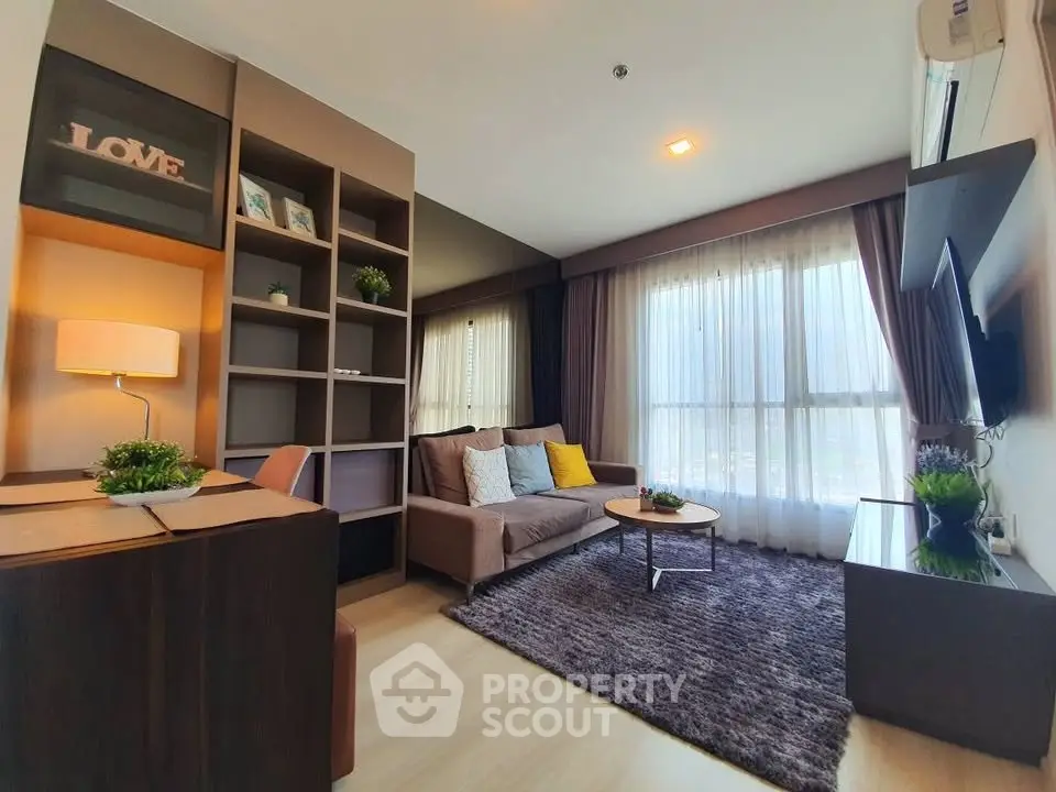 Modern living room with cozy sofa, stylish decor, and large window for natural light.