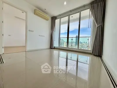 Spacious living room with large windows offering stunning city views and abundant natural light.
