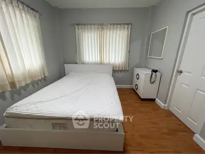 Cozy bedroom with natural light, featuring a comfortable bed and minimalist decor.