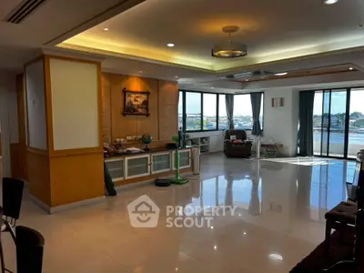 Spacious living room with large windows and elegant decor, offering a bright and inviting atmosphere.