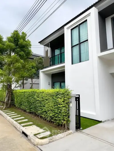Modern two-story house with lush greenery and sleek design