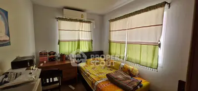 Cozy bedroom with natural light, featuring a single bed and study desk, perfect for a student or young professional.