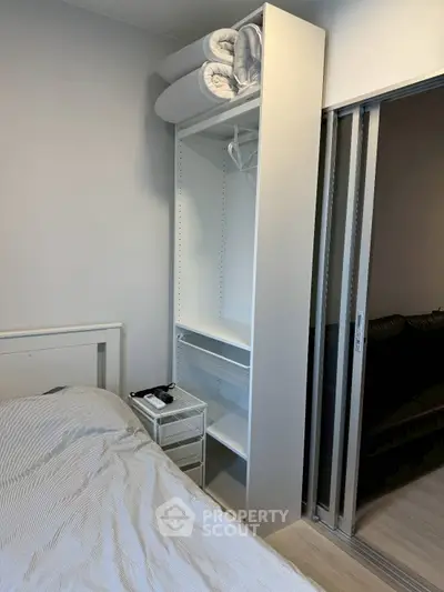 Modern bedroom with sleek storage and sliding glass doors, perfect for urban living.