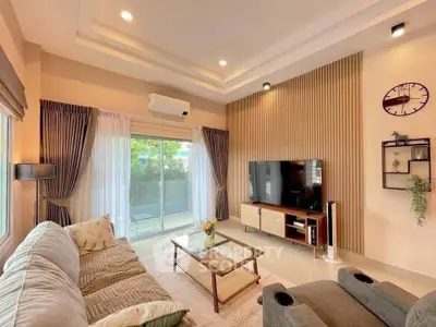 Modern living room with stylish decor, large TV, and cozy seating area, perfect for relaxation.