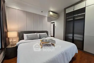 Luxurious bedroom with modern decor and cozy ambiance, featuring elegant lighting and ample storage space.