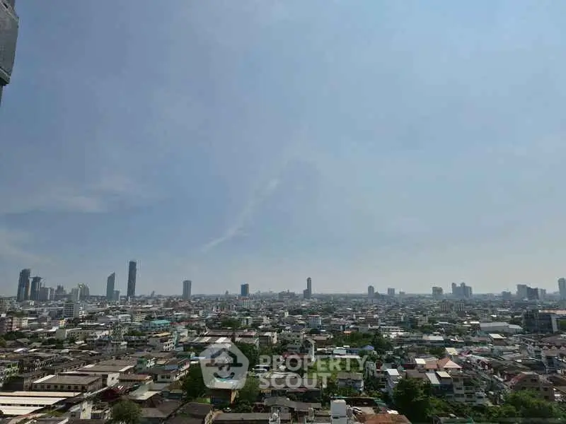 Stunning cityscape view from high-rise building showcasing urban skyline and clear blue sky.
