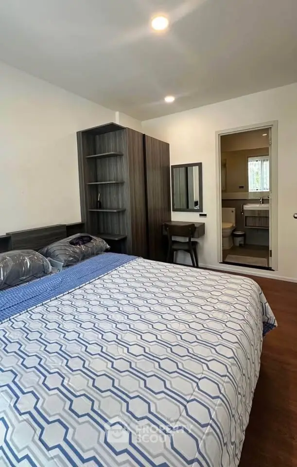 Spacious bedroom with modern furniture and ensuite bathroom in a stylish apartment.