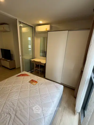 Modern bedroom with sleek design and ample natural light, featuring a cozy bed and stylish wardrobe.