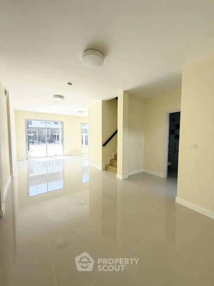 Spacious modern living room with glossy tiled floors and natural light