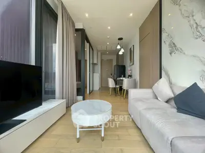 Modern living room with elegant decor and open layout, featuring a cozy sofa and stylish dining area.