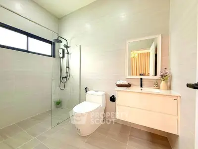 Modern bathroom with sleek design, featuring a glass shower enclosure and elegant fixtures.