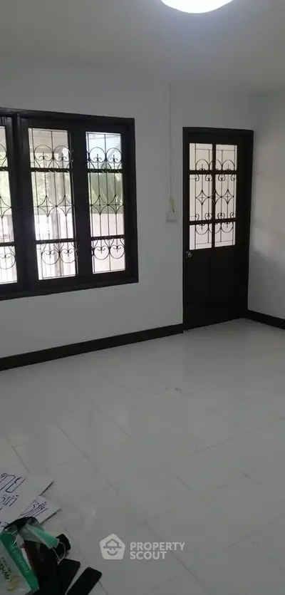 Spacious room with large windows and door, ideal for customization.