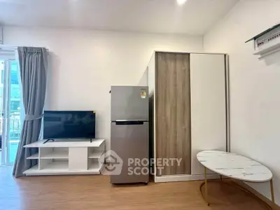 Modern living room with sleek furniture and appliances, featuring a fridge and TV stand.