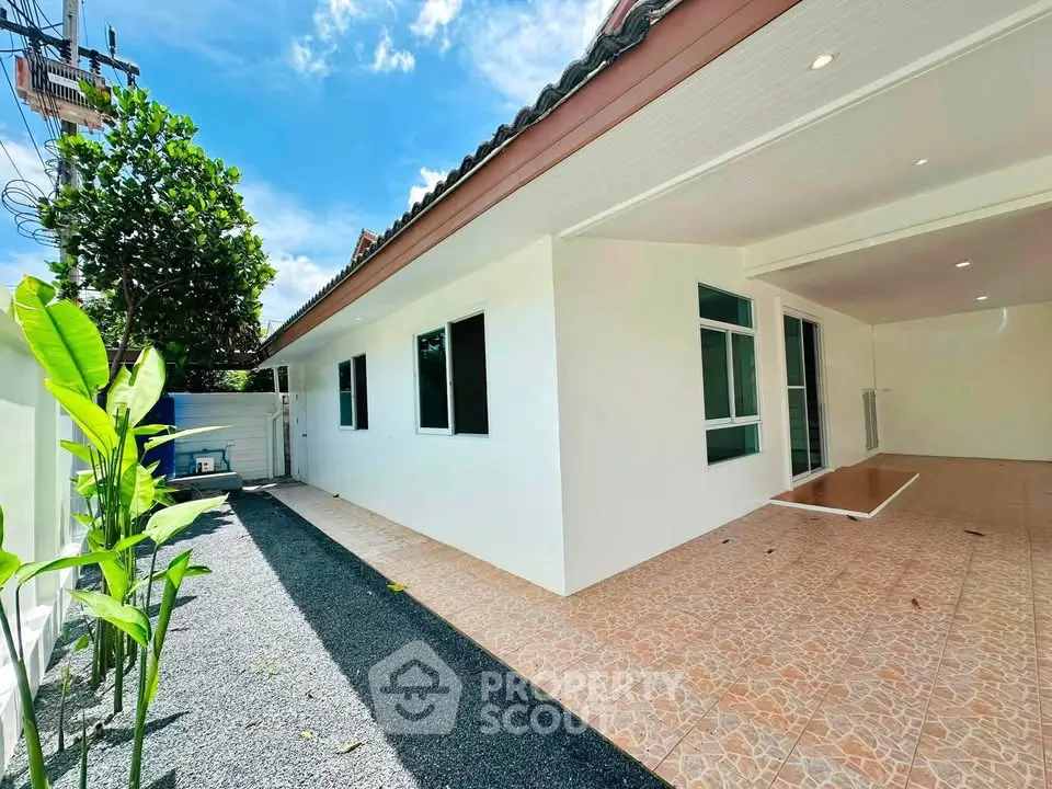 Charming single-story home with spacious driveway and lush greenery, perfect for serene living.