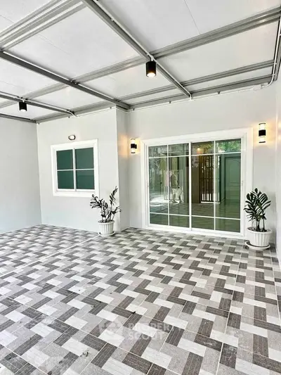 Modern covered patio with stylish tile flooring and sliding glass doors
