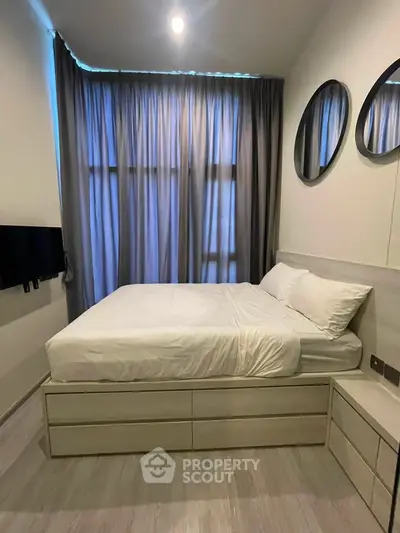 Modern bedroom with stylish decor and ample natural light, featuring a comfortable bed and sleek furnishings.
