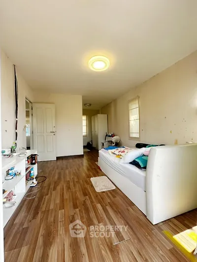 Spacious living room with wooden flooring and cozy sofa in bright apartment