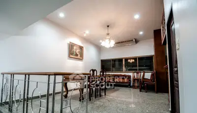 Elegant dining area with chandelier and classic furniture in a spacious open layout.