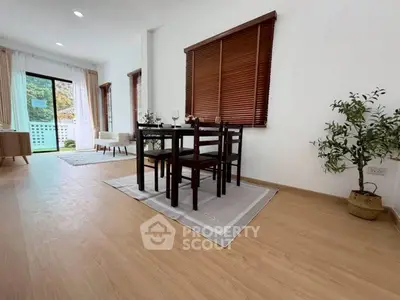Spacious living room with dining area and large windows in modern apartment.