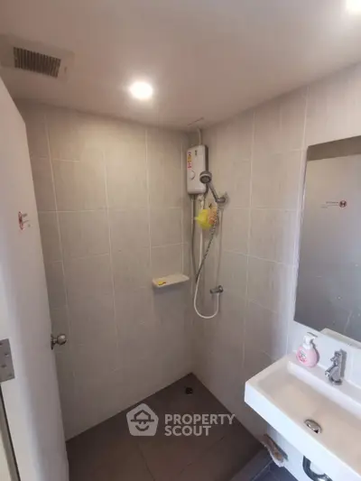 Modern bathroom with shower and sink in a compact space