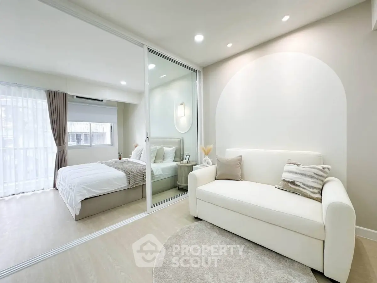 Modern bedroom with glass partition and cozy living area in elegant apartment