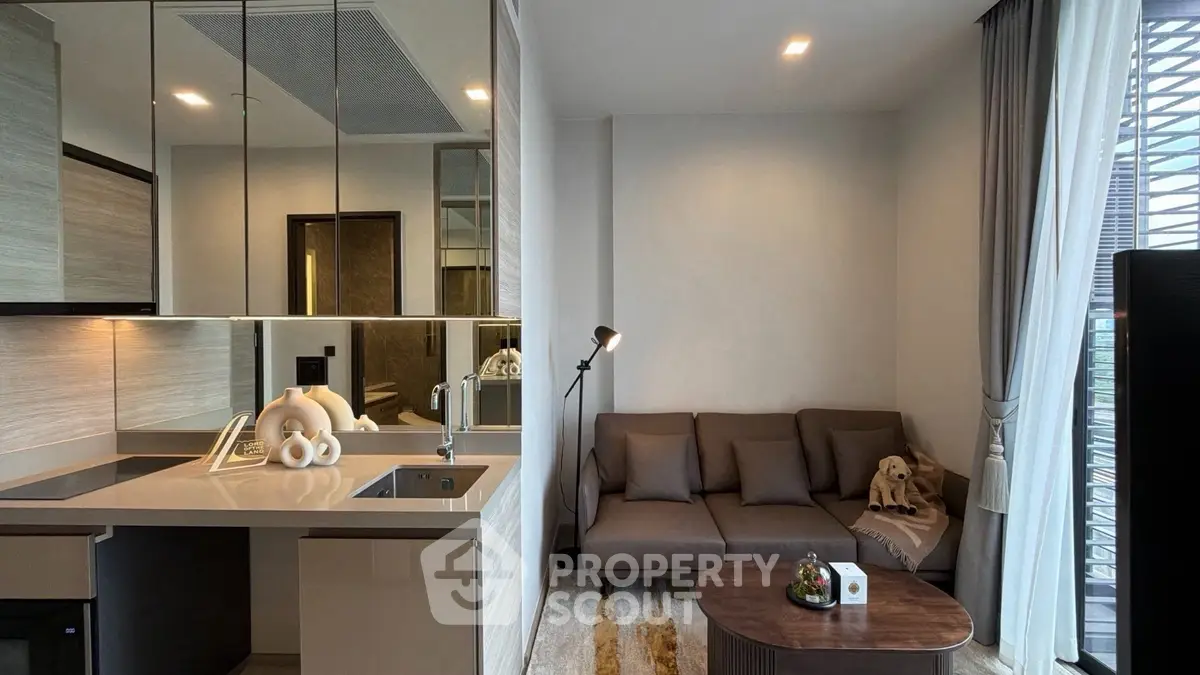 Modern living room with sleek kitchen, cozy sofa, and stylish decor in a contemporary apartment.
