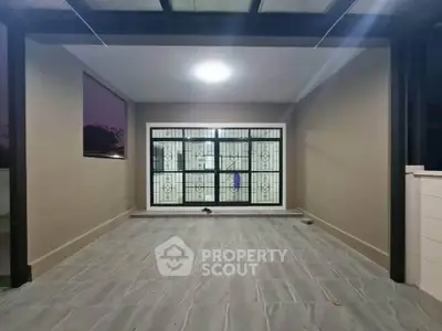 Spacious covered patio with modern tiled flooring and large window view