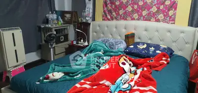 Cozy bedroom with colorful bedding and tufted headboard, perfect for relaxation.