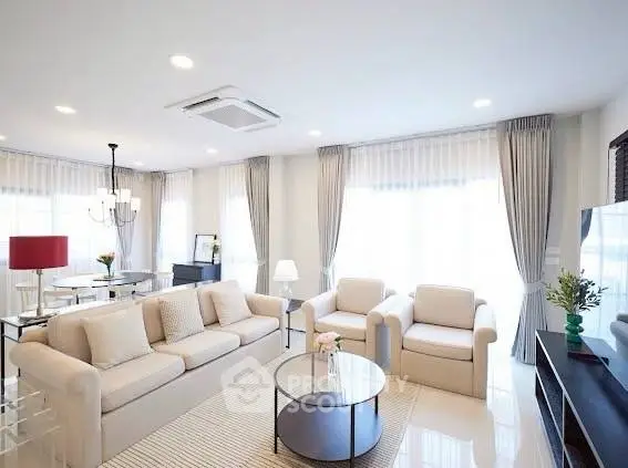Spacious and bright living room with modern decor and large windows.
