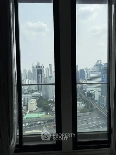 Stunning cityscape view from high-rise apartment window, showcasing urban skyline and modern architecture.