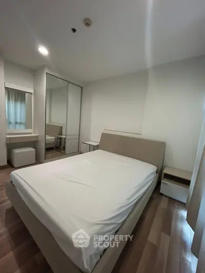 Modern bedroom with sleek design, featuring a comfortable bed and mirrored wardrobe, perfect for urban living.