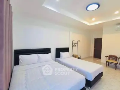 Spacious bedroom with two beds and modern lighting in a cozy apartment.