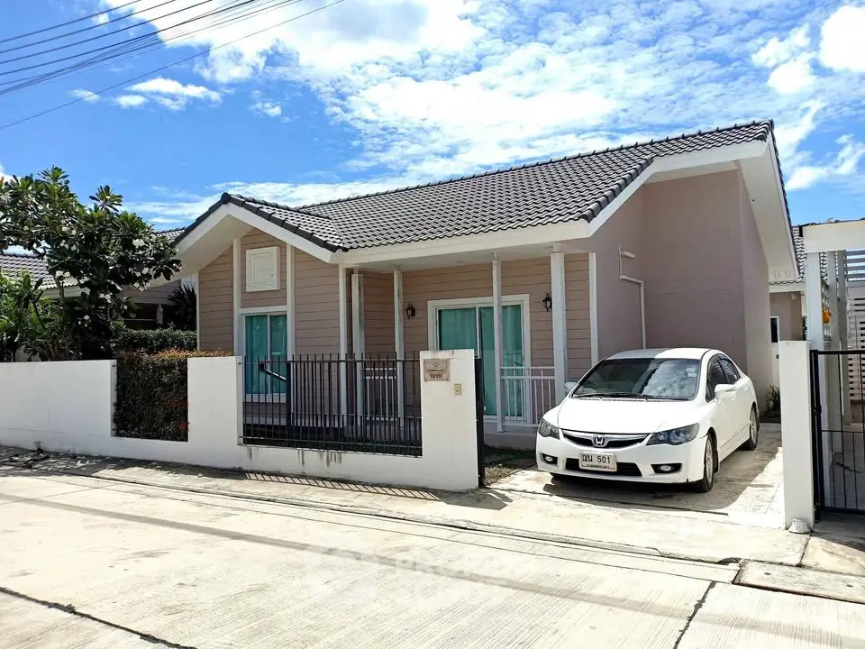 Charming single-story house with driveway and car, perfect for modern living in a serene neighborhood.