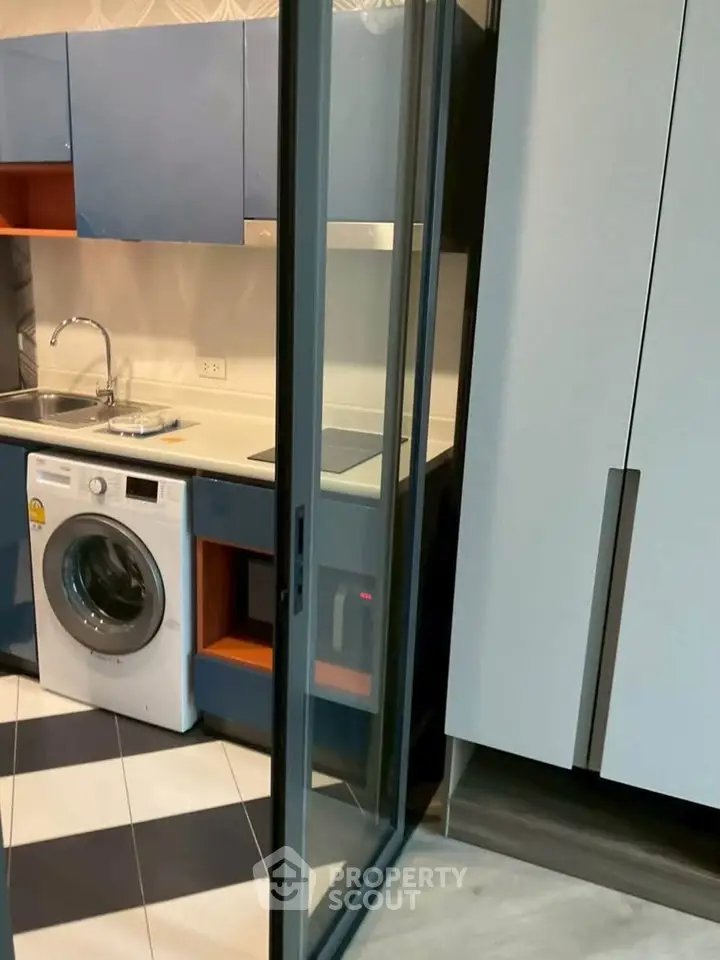 Modern kitchen with sleek cabinetry and built-in washing machine
