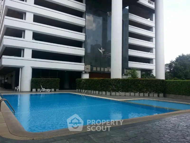 Luxurious residential building with a pristine outdoor swimming pool and modern architecture.