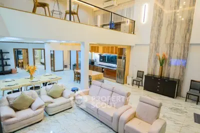 Luxurious open-plan living room with modern kitchen and elegant marble flooring.