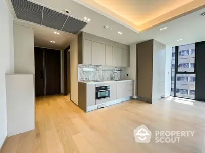 Modern open-layout kitchen with sleek cabinetry and built-in appliances in a bright apartment.